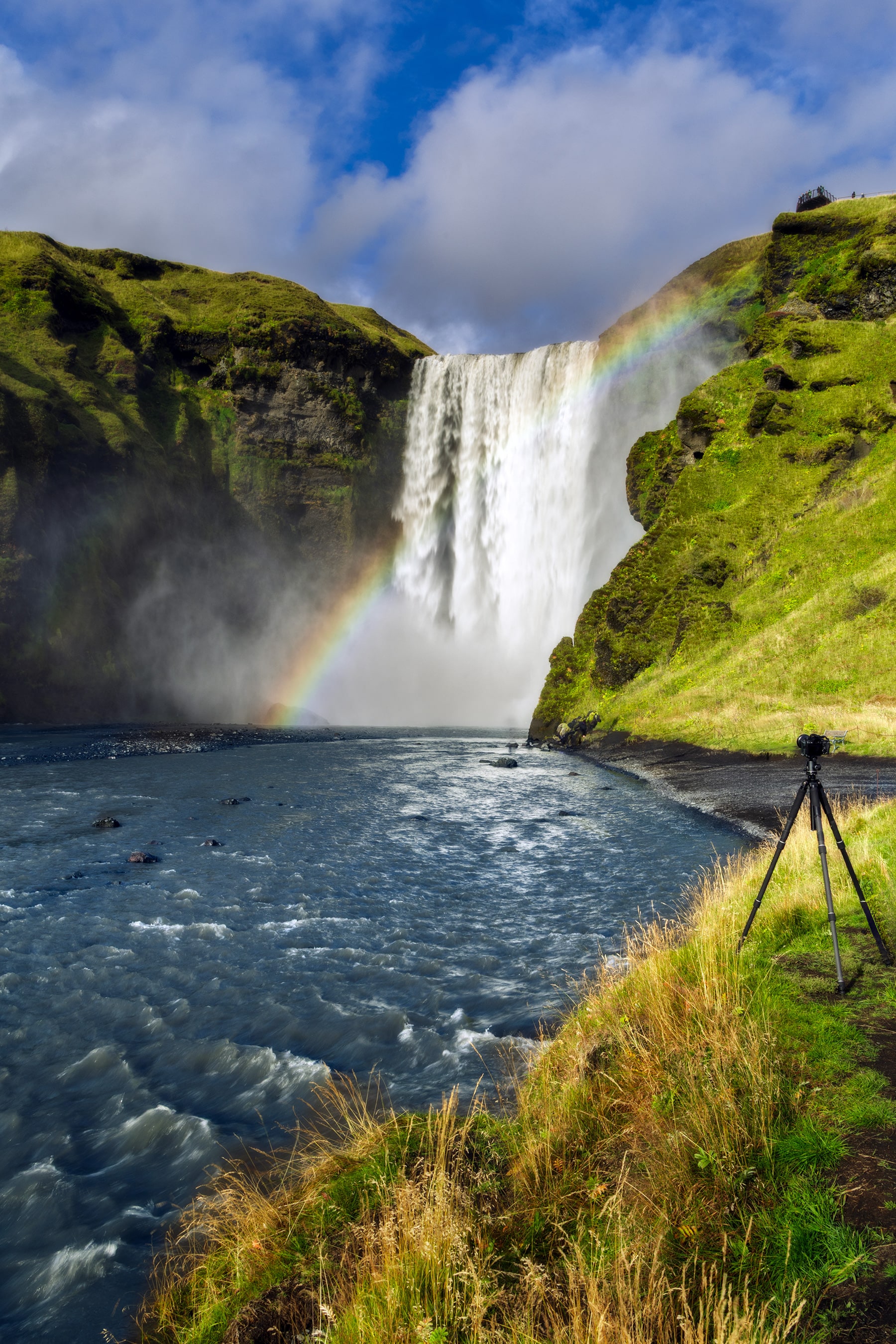 Skógafoss waterfall in South Iceland with a rainbow rising from the spray