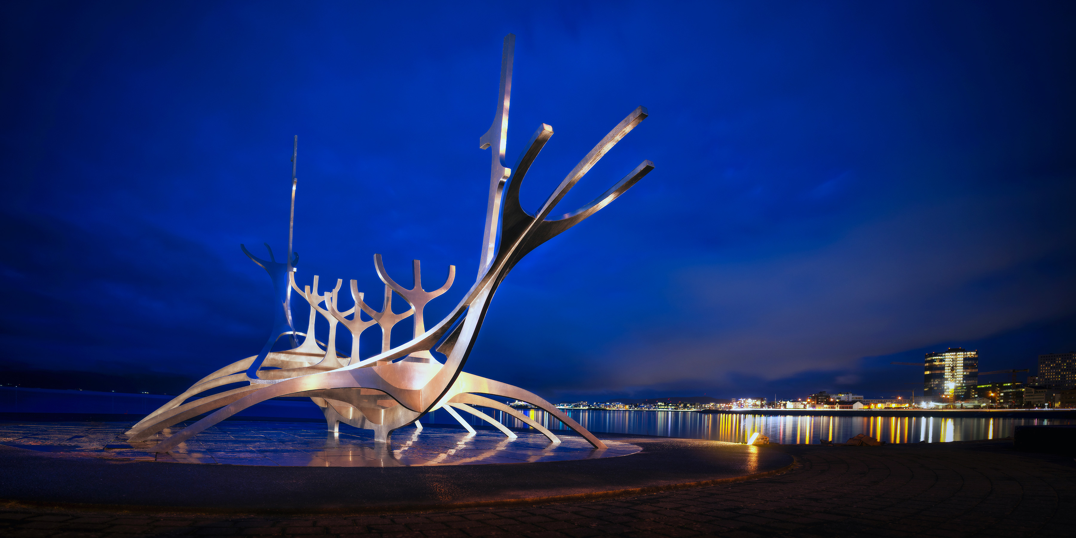 The Sun Voyager steel sculpture on the Reykjavik waterfront under a deep blue hour sky